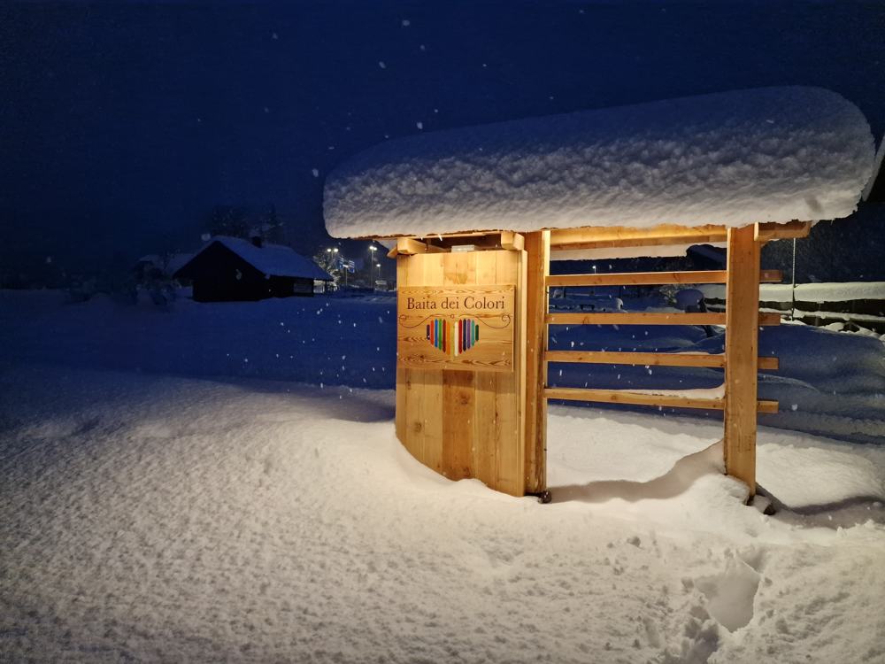 L’insegna della Baita dei Colori sotto la neve, di notte